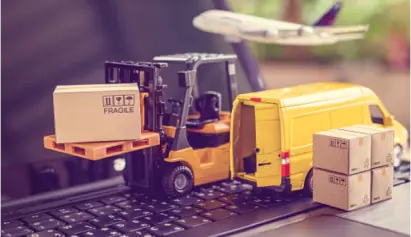 Mini forklift, boxes, and delivery van on laptop keyboard with plane overhead