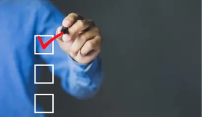 Person checks box on transparent board with red marker